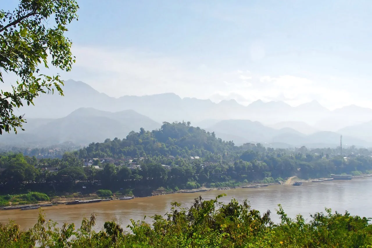 a vast area covered wit greenery with a river close to it.