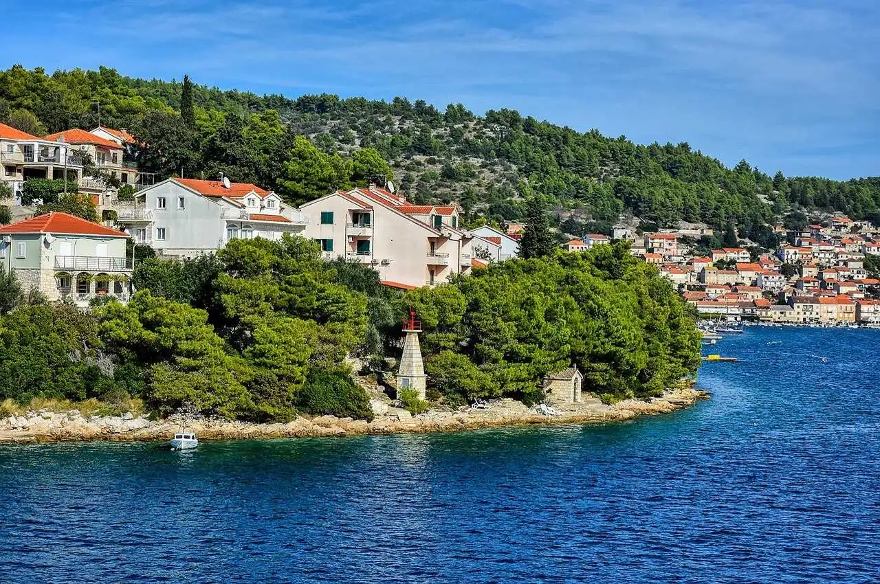 Houses on seaside and mountains covered with greenery on back