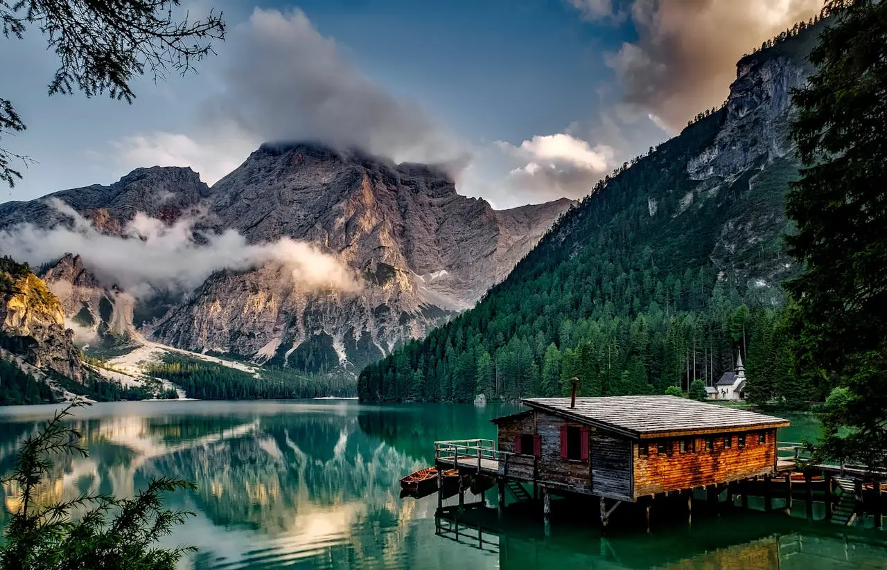 a cabin on a lake surrounded by mountains