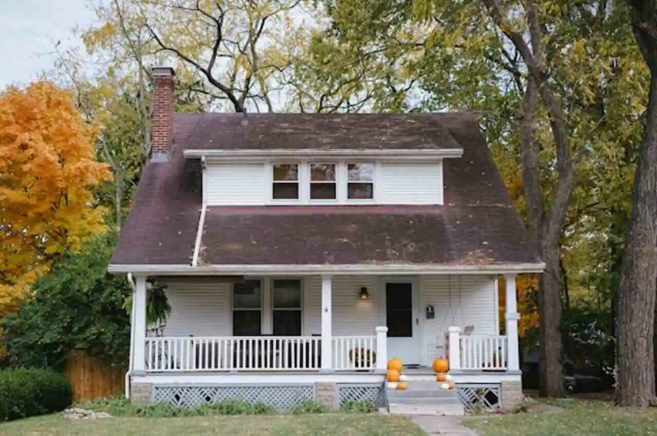 An old house with trees on its back.