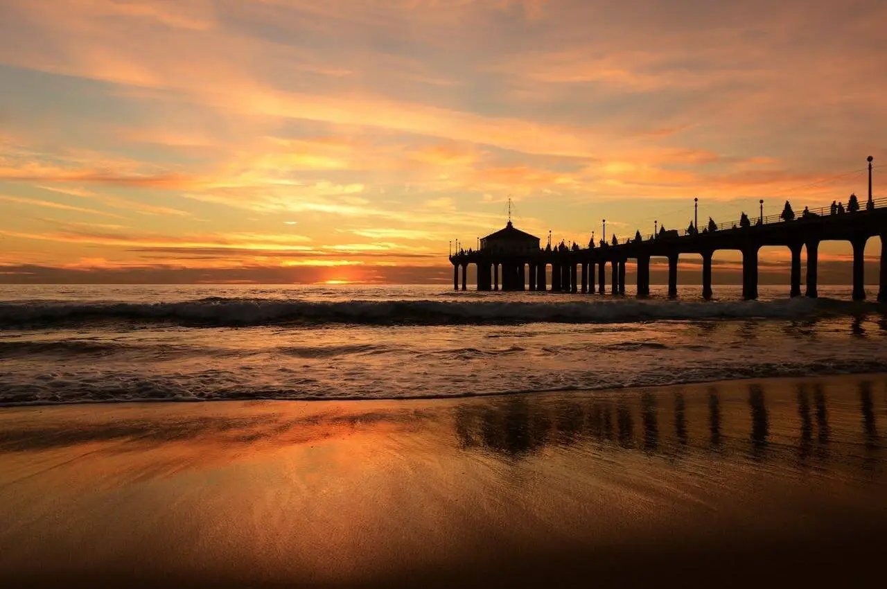 A pier on a beach with sunset views
