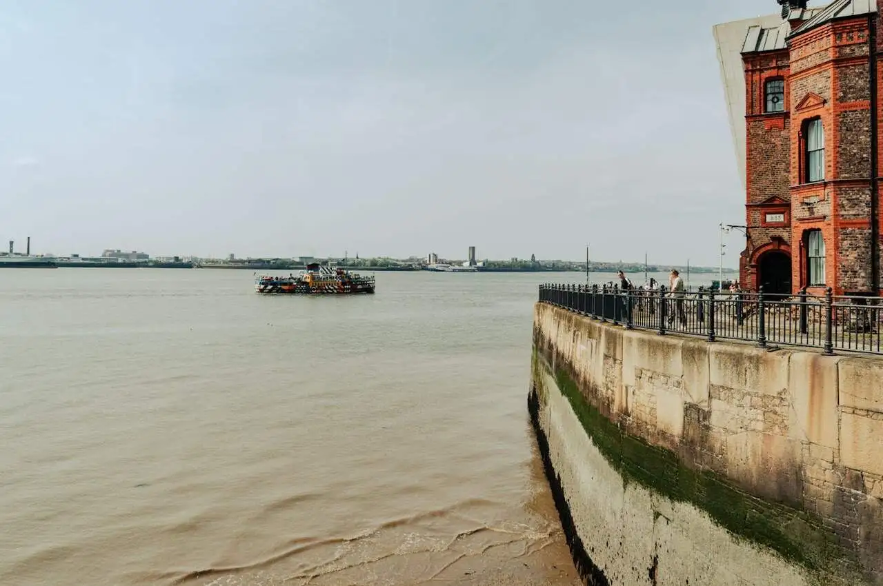 A ship in the water with people watching from land