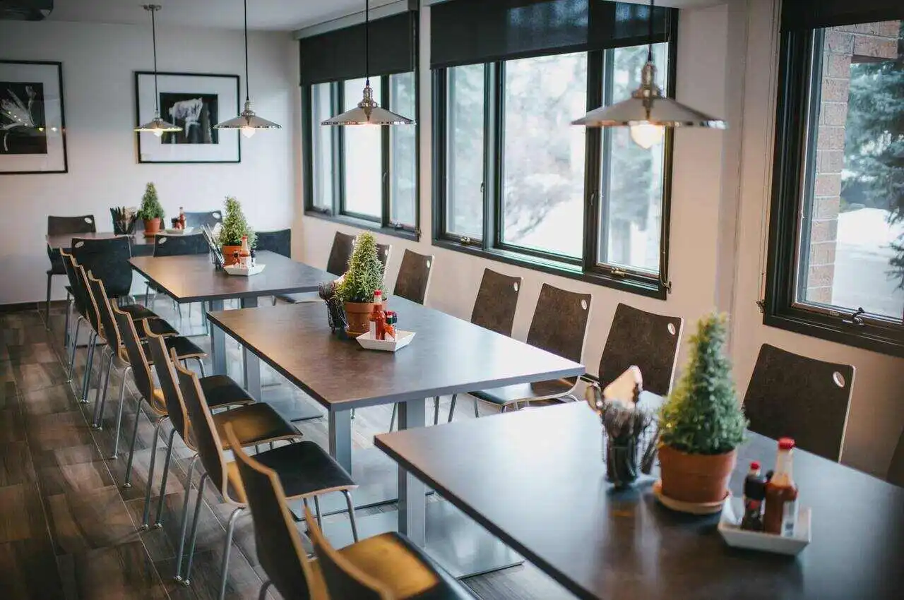 A dining table with sauces and flowers on top.