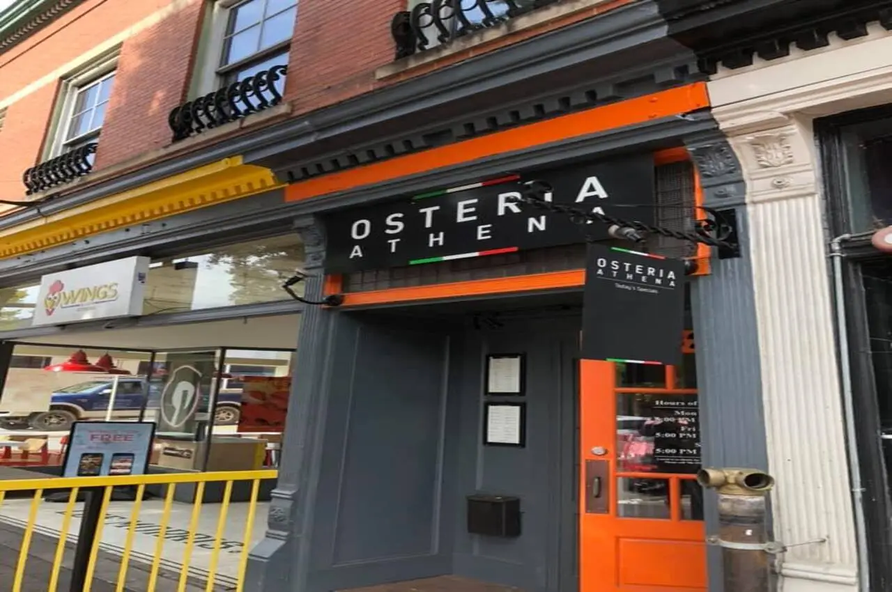 Entrance to Osteria Athena restaurant with a banner on top.
