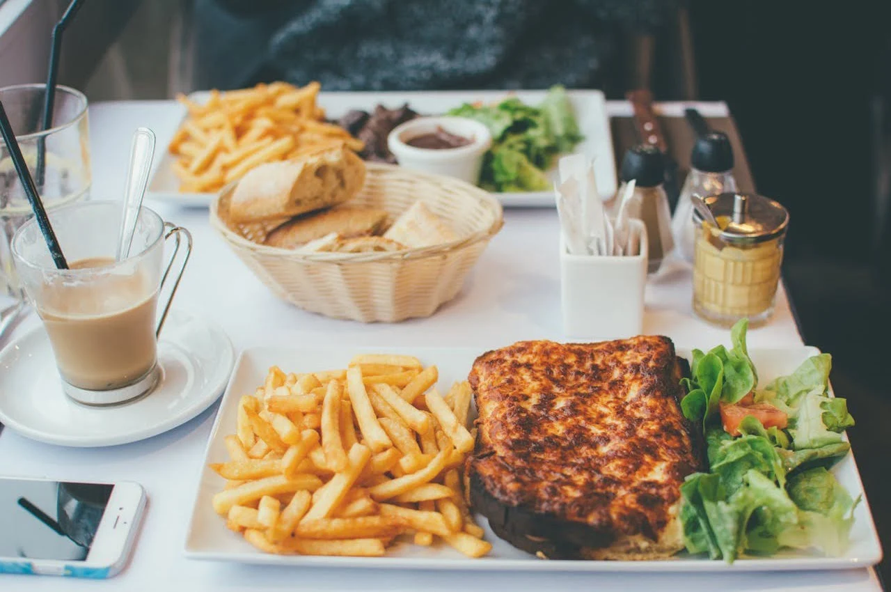 A serving of french fries, bread, tea, omelet, and salad.