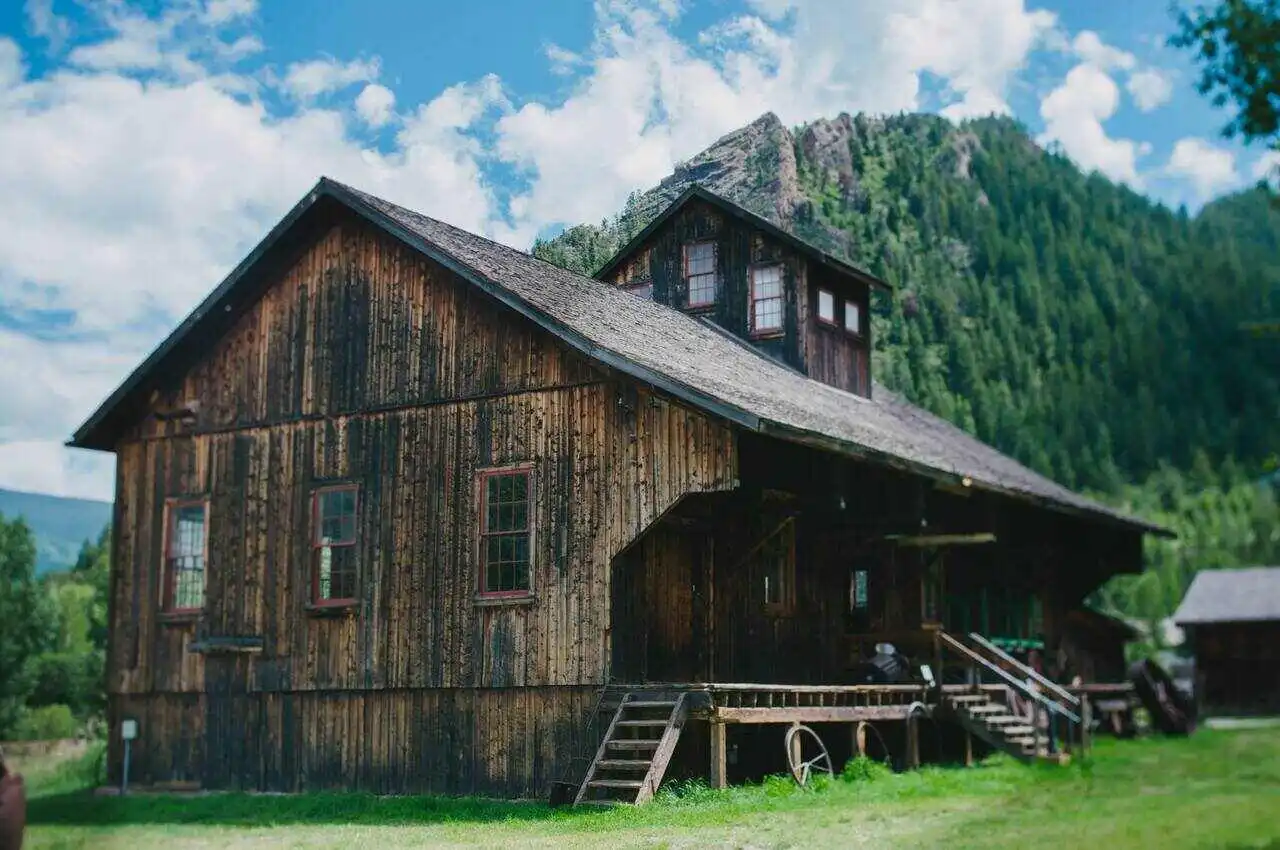 A historic wooden house with mountains on it’s back.