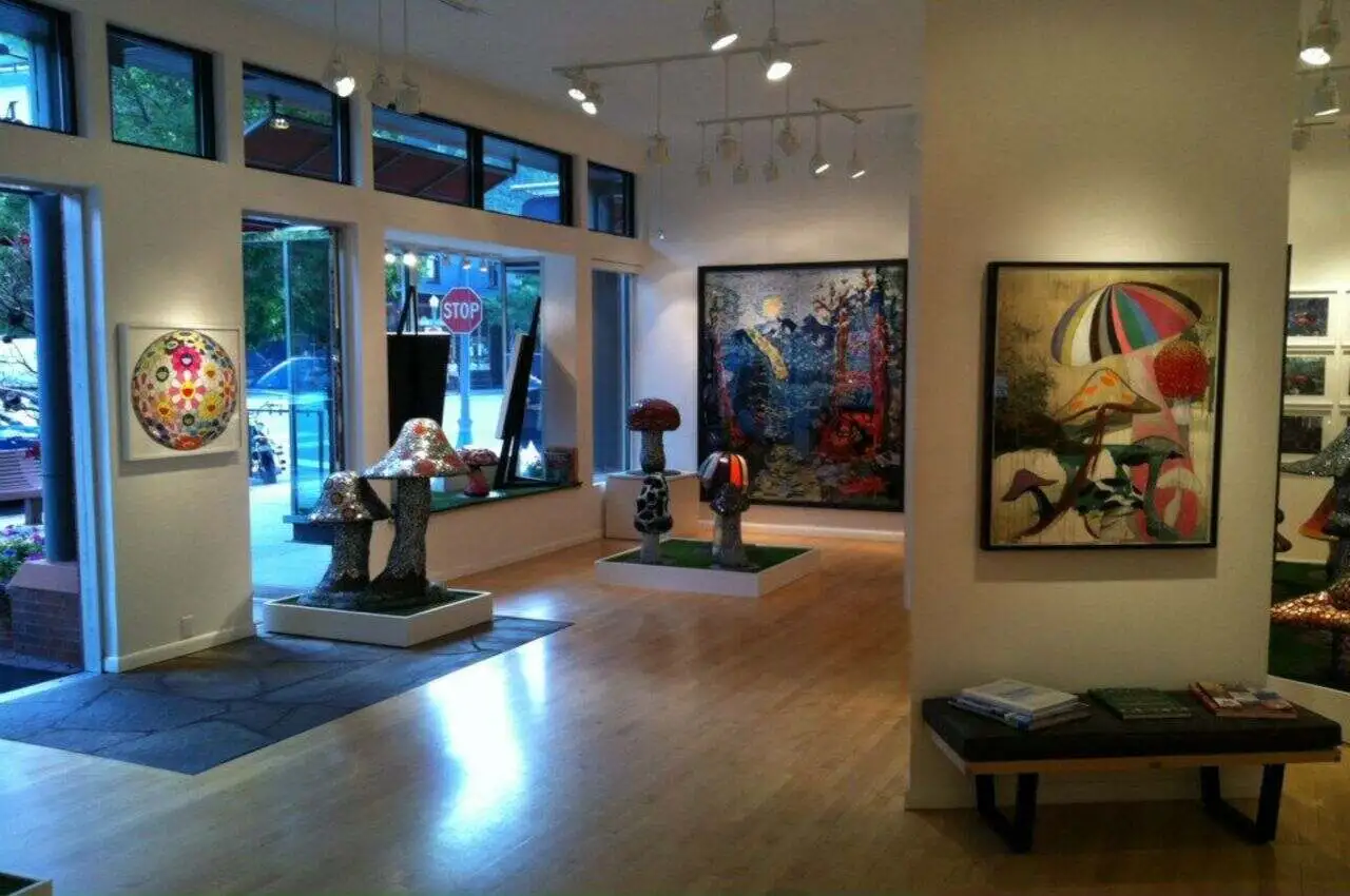 Inside an art gallery with different paintings hanging on the wall.