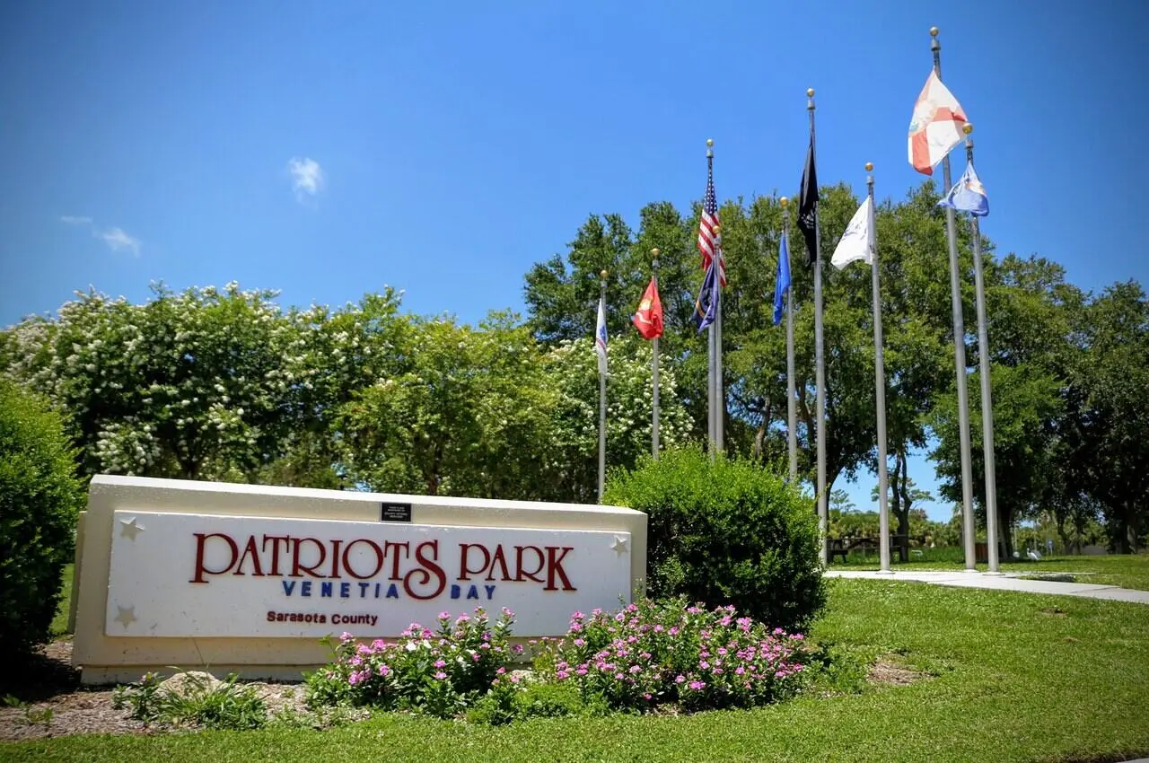 Patriot Park sign with different flags on the back.