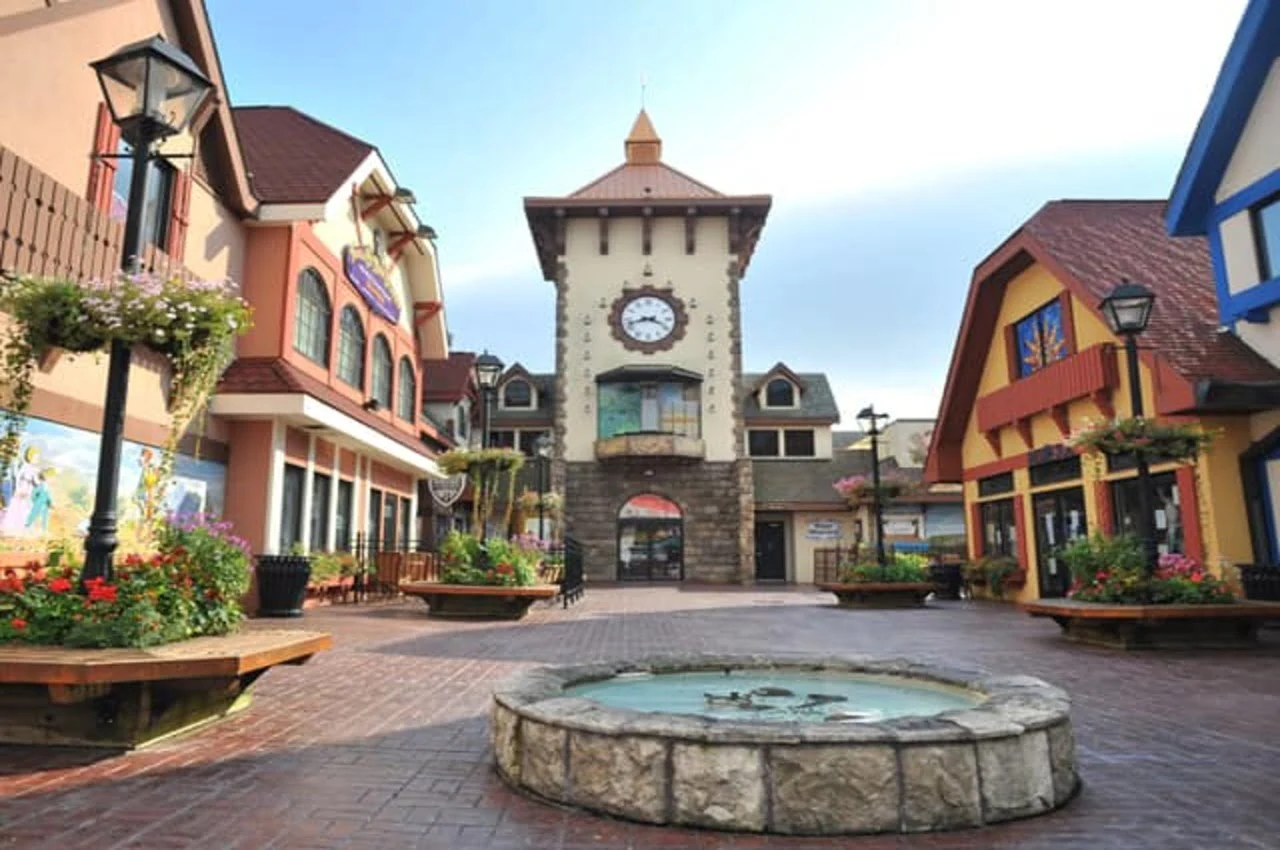 A street with shops on both sides and a clock tower at the end.