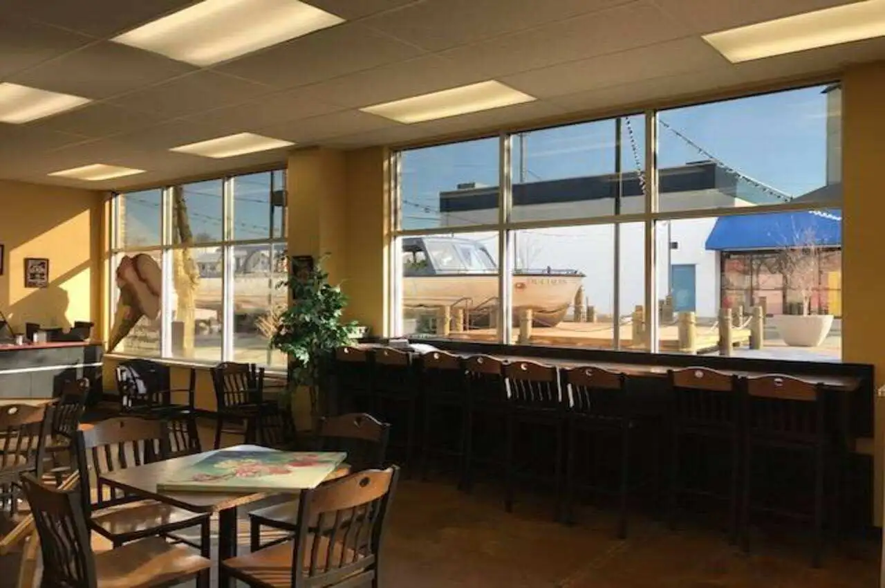 Tables and chairs with a window to view outside a restaurant.