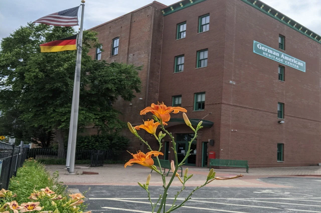 Building of German American Heritage Center with flags of America and Germany in front. 