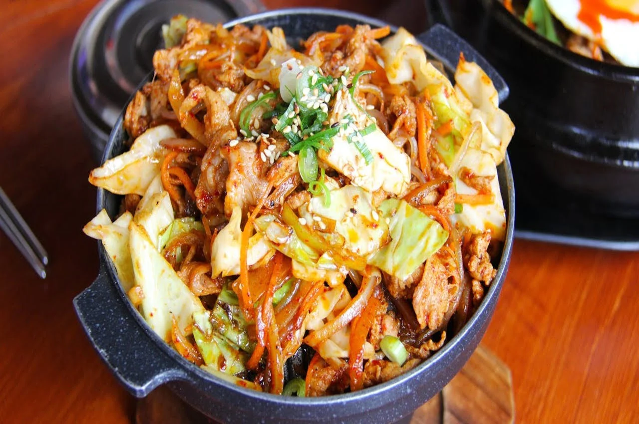 A bowl full of Thai food.
