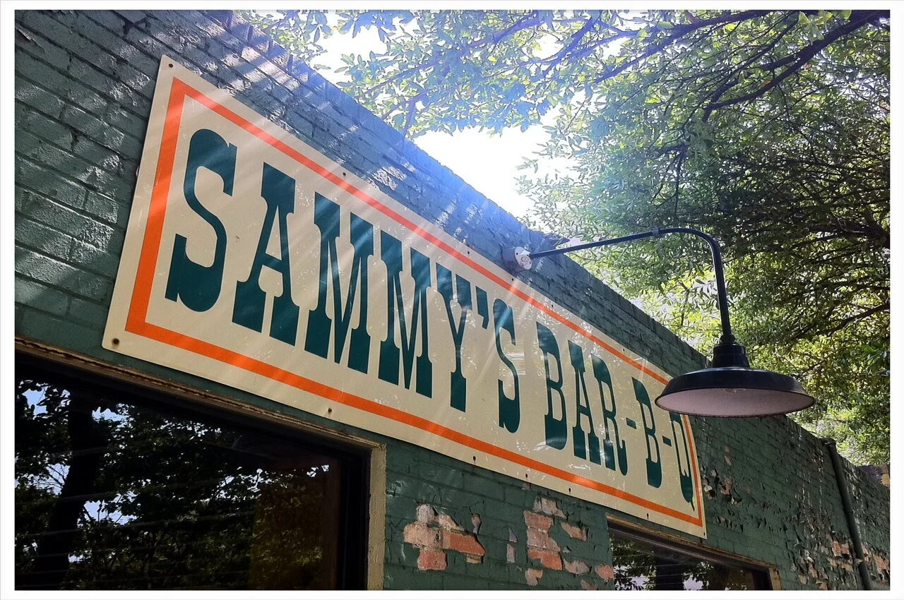 Banner of Sammy BBQ on the restaurant building.
