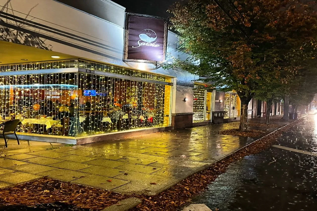 a building with lights on windows and trees