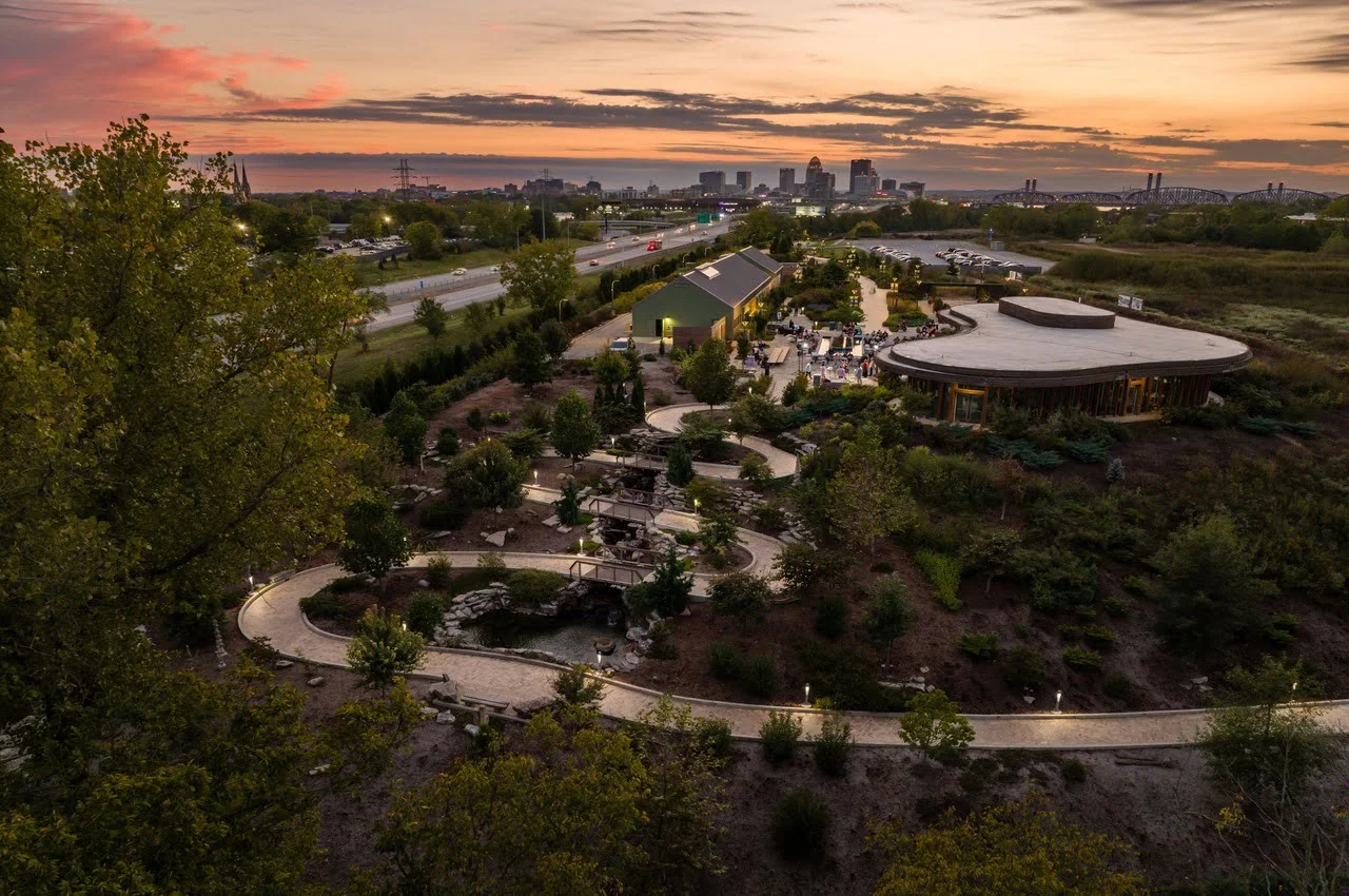 a landscape with a park and a road and buildings