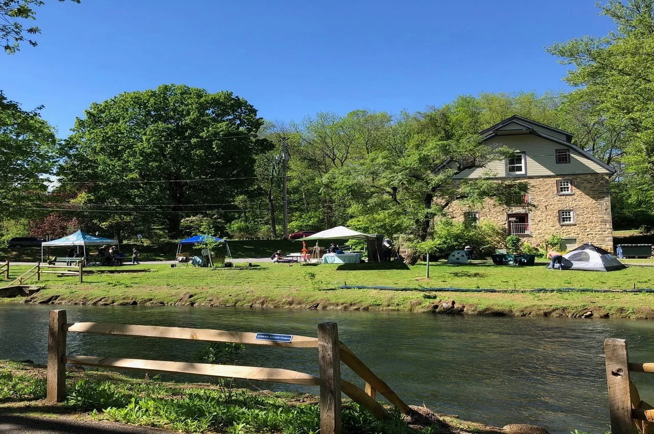 A lake flowing with a house on the other side