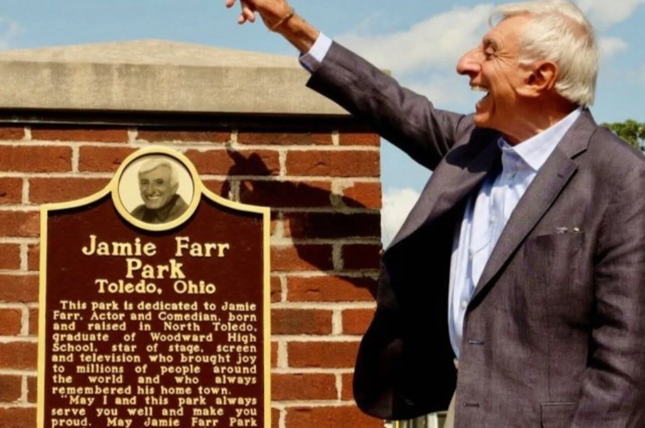 An individual standing in front of a plaque.