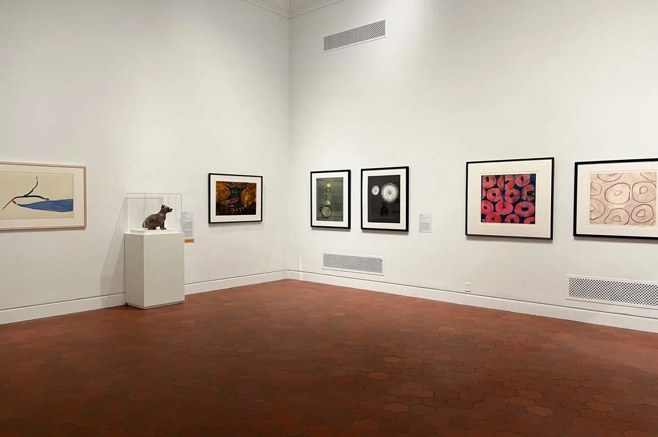 paintings and a sculpture of a dog in a pedestal
