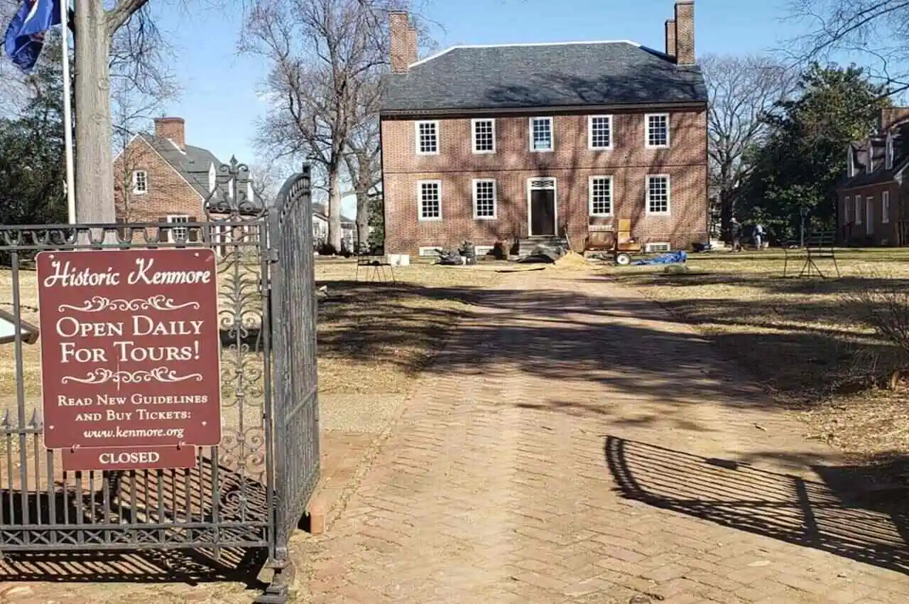 A mansion with a sign board in front.