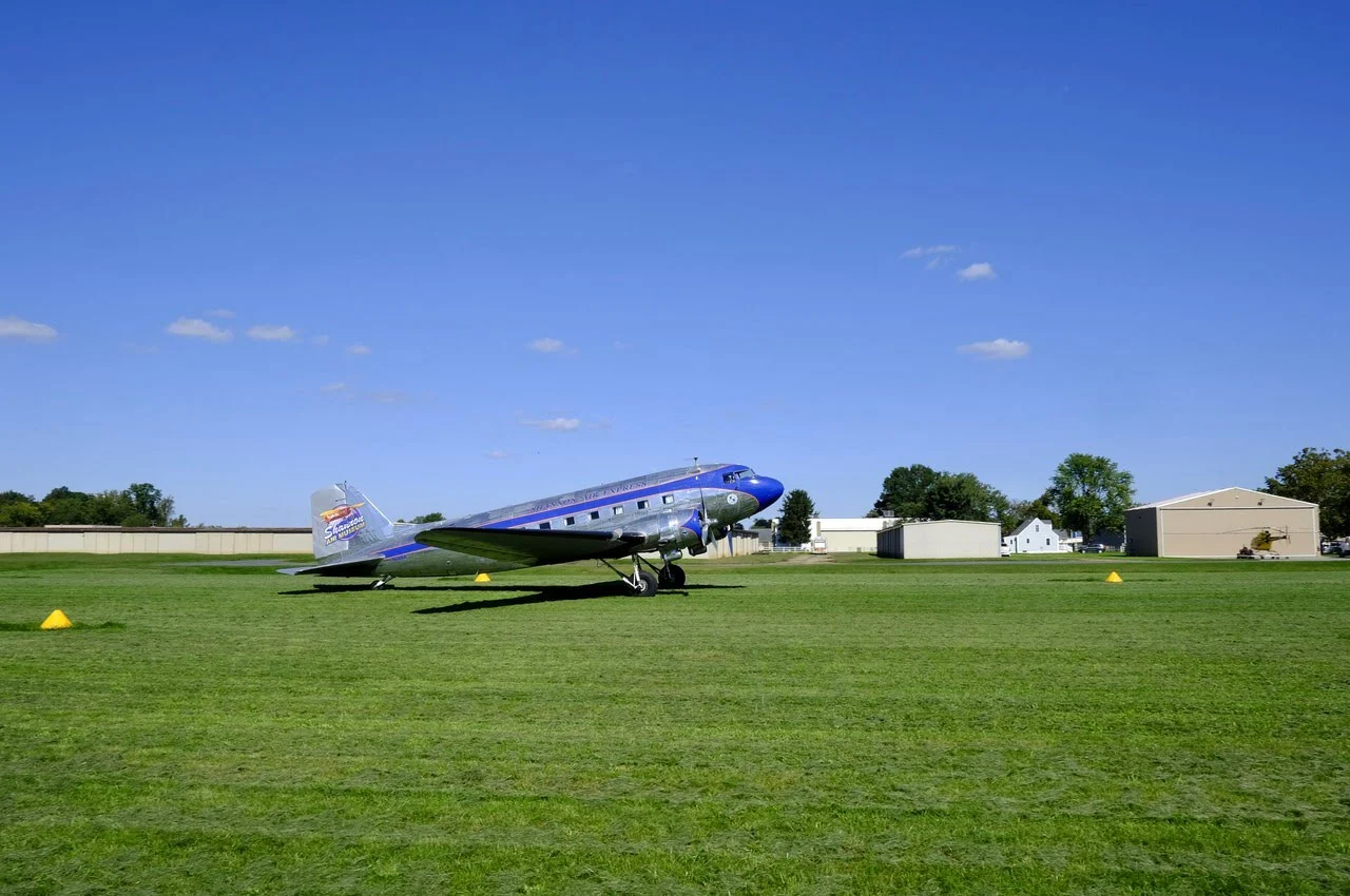 An aircraft with the backdrop of houses.