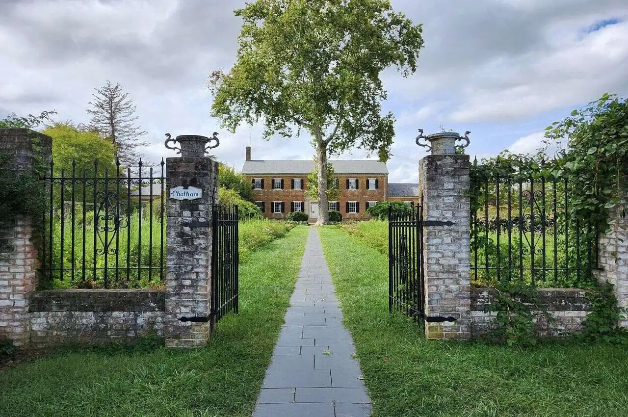 entrance to a mansion with garden in front.