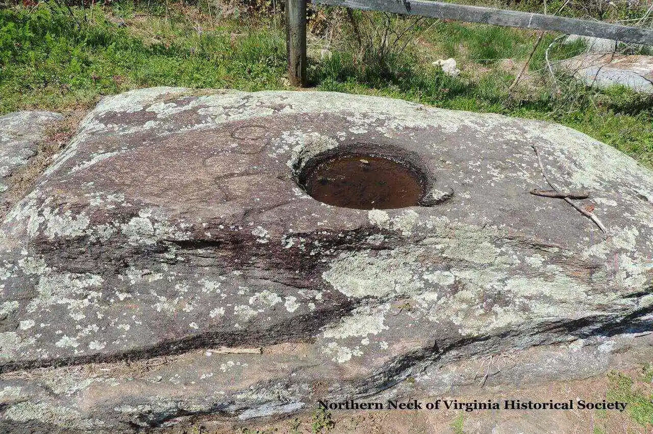 A rock formation with a hole in the middle filled with water.