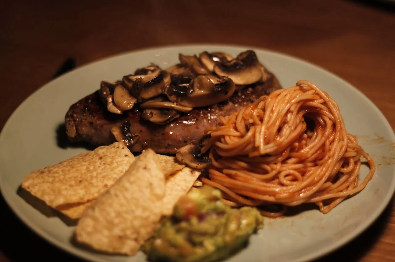 A plate of pasta and chicken.