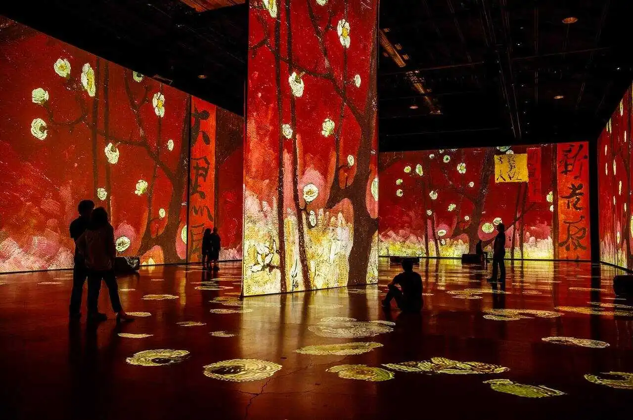 Inside an art gallery with visitors viewing the art.
