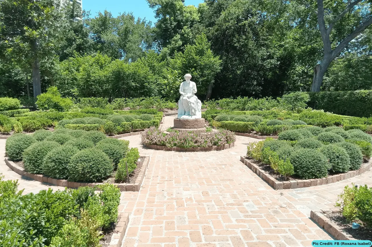 A garden with a sculpture in the middle.
