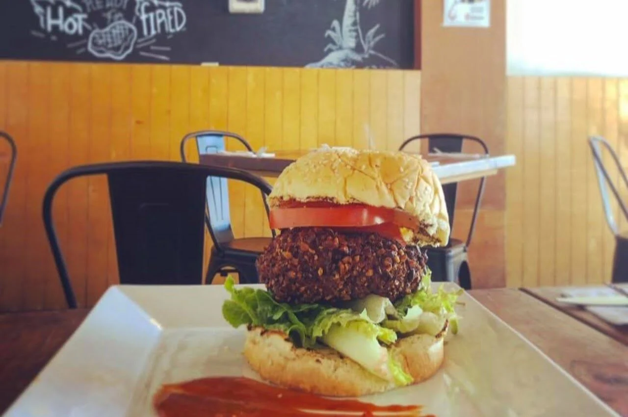 A burger with chairs on the back.