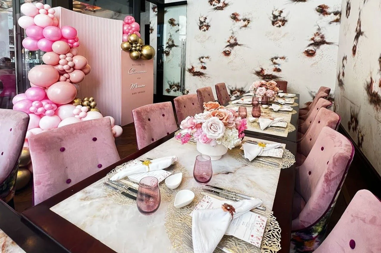 Pink dining table and chairs with a balloon on the back.
