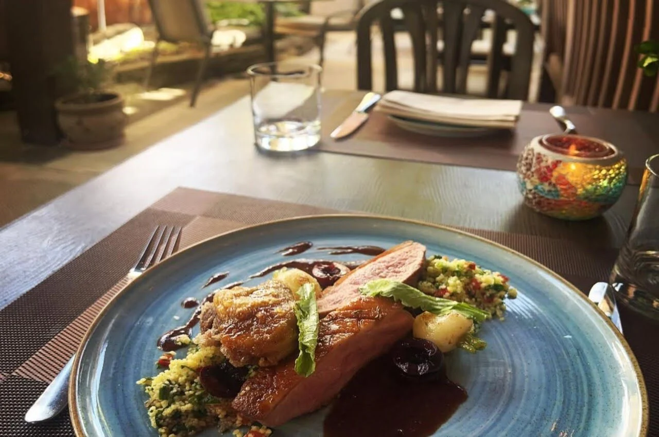 A dining table with beef Wellington on the plate.
